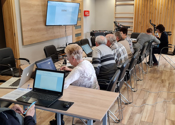 Zdjęcie przedstawia uczestników Klubu Seniora podczas zajęć komputerowych