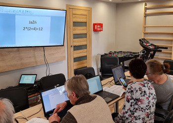 Zdjęcie przedstawia uczestników Klubu Seniora podczas zajęć komputerowych