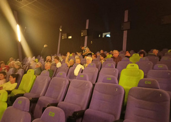 Zdjęcie uczestników klubu seniora w sali kinowej