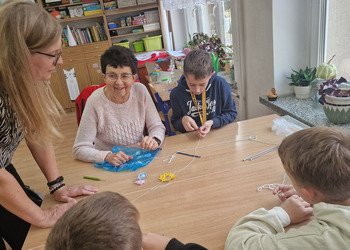 zdjęcie przedstawia babcie uczące szydełkowania