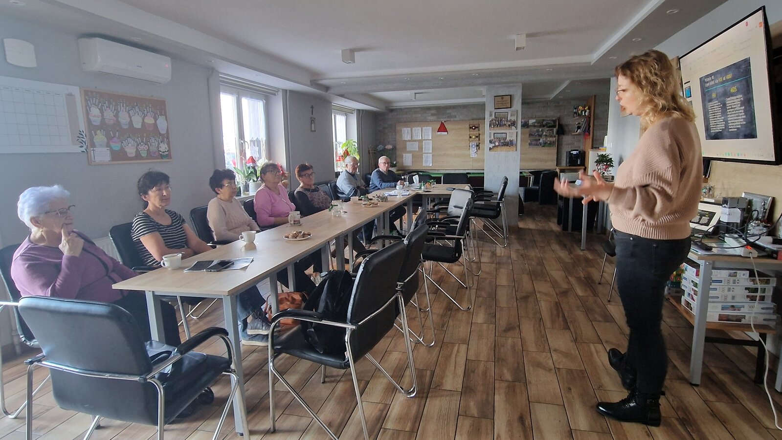 seniorzy oraz osoba prowadząca podczas prelekcji