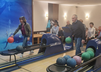 na zdjęciu seniorzy grają w kręgle 