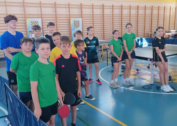 zdjęcie przedstawia uczestników biąrcych udział w turnieju tenisa stołowego podczas rozgrywek