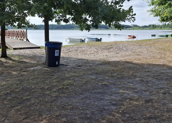 zdjęcie przedstawia kosz na śmieci nad jeziorem