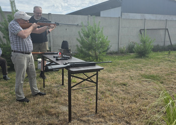 Zdjęcie przedstawia uczestników Klubu Seniora podczas zajęć na strzelnicy