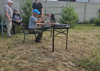 Zdjęcie przedstawia uczestników Klubu Seniora podczas zajęć na strzelnicy