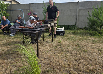 Zdjęcie przedstawia uczestników Klubu Seniora podczas zajęć na strzelnicy