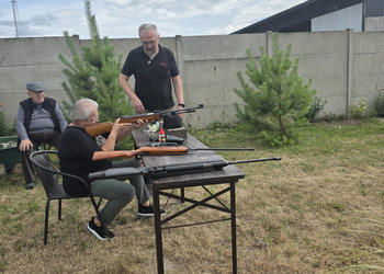 Zdjęcie przedstawia uczestników Klubu Seniora podczas zajęć na strzelnicy