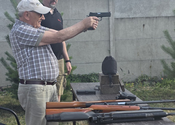 Zdjęcie przedstawia uczestników Klubu Seniora podczas zajęć na strzelnicy