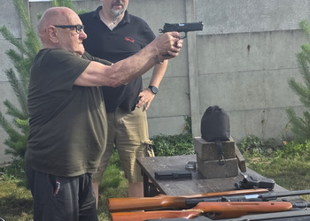 Zdjęcie przedstawia uczestników Klubu Seniora podczas zajęć na strzelnicy