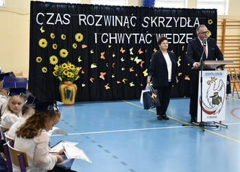 Zdjęcie przedstawia Wójta wraz z Przewodniczącą Rady  składającego życzenia pierwszoklasistom. 