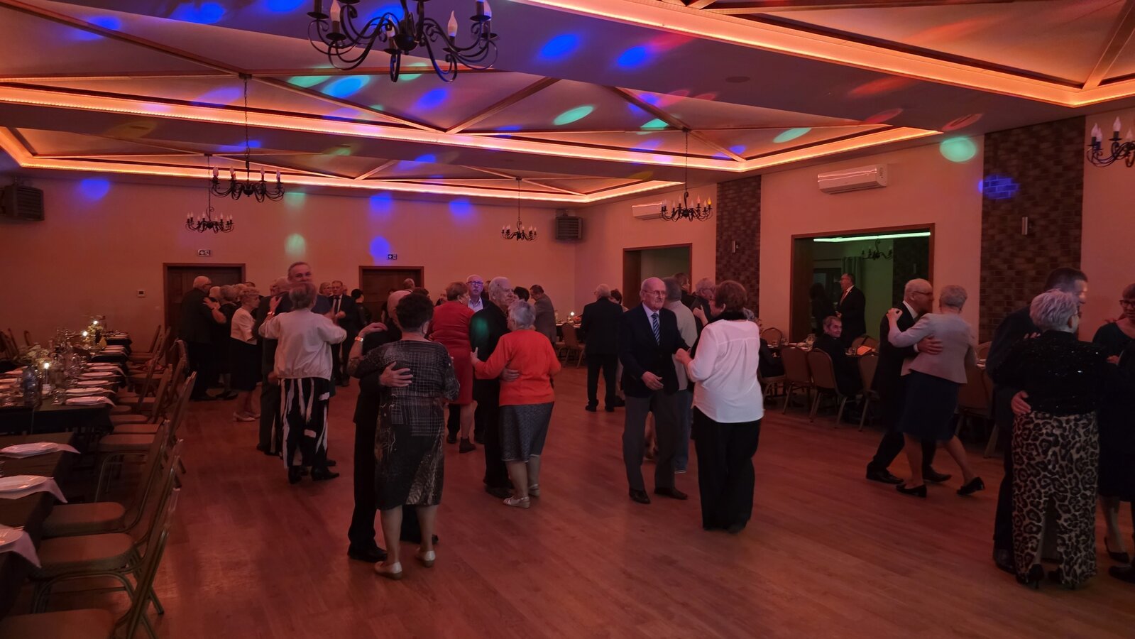 Zdjęcie przedstawia tańczących seniorów podczas zabawy andrzejkowej.